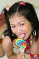 Nina licking lollipop on all fours