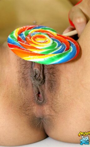 Nina strips short plaid skirt and shows shaved pussy while licking lollipop