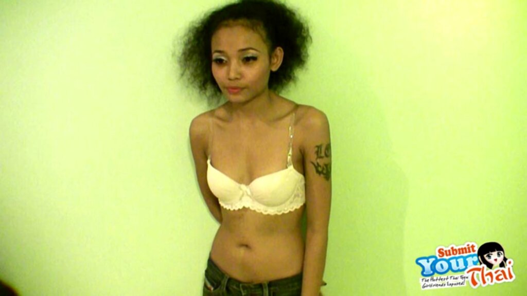 Standing in front of wall wearing bra tattoo on her upper arm
