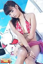Seated beside pool wearing bikini top legs pressed together