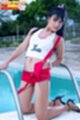 Kneeling beside swimming pool wearing white top in red shorts high heels