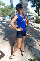 Standing outdoors with hands on hips short hair wearing sunglasses